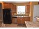 Bright kitchen featuring a black refrigerator, stainless steel dishwasher and tile floors at 3258 Starlite Ct, Columbus, IN 47203