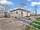 Rear view of home featuring simple landscaping, detached carport, and plenty of parking space on a paved driveway at 4592 Gordon Dr, Plainfield, IN 46168