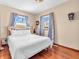 Bright bedroom with hardwood floors, neutral walls, a full size bed, and two large windows with decorative curtains at 4592 Gordon Dr, Plainfield, IN 46168