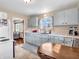 Well-lit kitchen featuring white cabinets, a modern sink, and hardwood floors in adjacent room at 4592 Gordon Dr, Plainfield, IN 46168