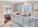 Well-lit kitchen features stainless steel sink, white cabinets, and hardwood floors in living area at 4592 Gordon Dr, Plainfield, IN 46168