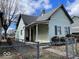 Exterior view of the house featuring a covered porch and chain link fence at 542 N Tremont St, Indianapolis, IN 46222