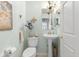 Charming half-bathroom with a chandelier, pedestal sink, and decorative touches at 6103 Lazy Ln, Indianapolis, IN 46259