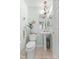Neat and tidy half-bathroom with a chandelier, pedestal sink, and tile floors at 6103 Lazy Ln, Indianapolis, IN 46259