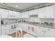 Kitchen with white cabinets, stainless steel appliances, and laminate wood floors at 6103 Lazy Ln, Indianapolis, IN 46259