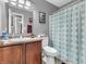 Bathroom with vanity, mirror, patterned shower curtain, and artwork at 6905 Percy Dr, Indianapolis, IN 46113