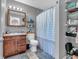 Bathroom with a single sink vanity and a shower/tub combination, plus storage shelving at 6905 Percy Dr, Indianapolis, IN 46113