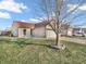 Charming single-Gathering home featuring a well-maintained front yard with green grass, a mature tree, and an attached two-car garage at 6905 Percy Dr, Indianapolis, IN 46113