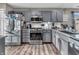 Modern kitchen features gray cabinetry, granite countertops, stainless steel appliances, and subway tile backsplash at 6905 Percy Dr, Indianapolis, IN 46113
