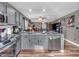 Spacious kitchen with gray cabinets, stainless steel appliances, and granite countertops that opens to the living room at 6905 Percy Dr, Indianapolis, IN 46113