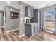 A beautifully designed coffee bar area with gray cabinets and granite countertops in a naturally lit room at 6905 Percy Dr, Indianapolis, IN 46113