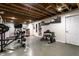 Spacious basement gym with exposed wood ceiling, weightlifting equipment, and ample lighting at 7671 Sherry Ln, Brownsburg, IN 46112