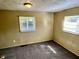 Modest bedroom with carpeted floors, two windows, and neutral wall color at 823 Collier St, Indianapolis, IN 46241