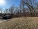 Exterior view of detached garage with a dark door and siding in a wooded setting at 8468 N Baltimore Rd, Monrovia, IN 46157