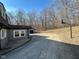 View of a driveway with a home and detached garage surrounded by bare trees at 8468 N Baltimore Rd, Monrovia, IN 46157