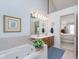Elegant bathroom featuring a soaking tub, double vanity, and modern lighting at 9694 River Oak E Ln, Fishers, IN 46038