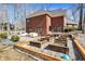 Rear view of a brick home with a large backyard featuring a patio and raised garden beds at 11850 Deer Walk Dr, Cicero, IN 46034
