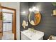 Stylish powder room with modern fixtures, shiplap wall, and attractive round mirror at 11850 Deer Walk Dr, Cicero, IN 46034