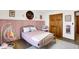 Charming bedroom with pink wainscotting, a gold bed frame, and a cozy swing chair at 11850 Deer Walk Dr, Cicero, IN 46034
