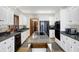 Bright kitchen featuring white cabinets, black appliances, and a large granite-topped island with cooktop at 11850 Deer Walk Dr, Cicero, IN 46034