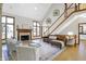 Bright living room with fireplace, hardwood floors, large windows, and staircase at 11850 Deer Walk Dr, Cicero, IN 46034