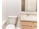 Close up of a white toilet and vanity with tan wood-look cabinets in a bathroom at 12243 Belfry Dr, Noblesville, IN 46060