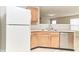 Kitchen featuring stainless steel dishwasher, white fridge, light wood cabinetry, and modern countertops at 12243 Belfry Dr, Noblesville, IN 46060