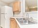 Well-lit kitchen with light wood cabinetry, double basin sink, and bright white refrigerator at 12243 Belfry Dr, Noblesville, IN 46060