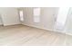 Bright living room featuring light-colored walls, wood floors, and natural light from two windows and a door at 12243 Belfry Dr, Noblesville, IN 46060