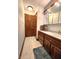 Bathroom featuring wooden vanity, mirrored medicine cabinet, tile floors, and a fluffy blue rug at 1285 W Judson Ln, Mooresville, IN 46158