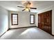 Bright bedroom featuring carpeted floors, two windows, and a spacious closet with paneled wood doors at 1285 W Judson Ln, Mooresville, IN 46158