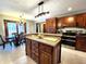 Kitchen island with seating, stainless appliances, granite countertops, and view to dining area at 1285 W Judson Ln, Mooresville, IN 46158