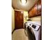 Laundry room showcasing wooden cabinets, a tile floor, and modern front-load washer and dryer at 1285 W Judson Ln, Mooresville, IN 46158