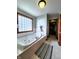 Large soaking tub offers a glass block window, tile surround, and striped rug at 1285 W Judson Ln, Mooresville, IN 46158