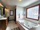 Main bathroom has a soaking tub next to a glass block window for natural light and privacy at 1285 W Judson Ln, Mooresville, IN 46158