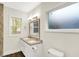 Bright bathroom featuring a double sink vanity, a modern toilet, and a window at 1304 N Tuxedo St, Indianapolis, IN 46201