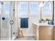 Bright bathroom featuring a walk-in shower with tiled walls, modern vanity, and ample natural light from two windows at 13383 Vickery Ridge Dr, Fishers, IN 46037