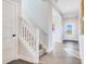 Hallway with stairs leading upstairs and a view of the front door and blue door and light floors at 13383 Vickery Ridge Dr, Fishers, IN 46037