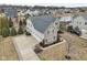 Aerial view of a two-story home with a three-car garage, mature trees, and a pond in the neighborhood at 14466 Integrity Ct, Carmel, IN 46033
