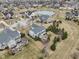 Expansive aerial view of a neighborhood with a pond, showcasing the community's layout and surrounding landscape at 14466 Integrity Ct, Carmel, IN 46033
