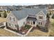 An aerial view of a grand home with stone and siding exterior and beautiful landscaping in a suburban neighborhood at 14466 Integrity Ct, Carmel, IN 46033