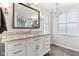 Bright bathroom with a granite countertop, white cabinets, and a window at 14466 Integrity Ct, Carmel, IN 46033