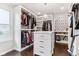 Bright walk-in closet featuring custom shelving, drawers, hardwood floors and stylish decorative accents at 14466 Integrity Ct, Carmel, IN 46033