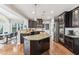 A kitchen boasts dark cabinets, stainless steel appliances and a granite countertop island with pendant lighting at 14466 Integrity Ct, Carmel, IN 46033