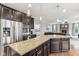 Spacious kitchen featuring a granite countertop island, stainless appliances, and dark wood cabinets with pendant lights at 14466 Integrity Ct, Carmel, IN 46033