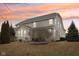 The back of the home is enhanced by an outdoor patio and a beautifully colored sunset sky at 14466 Integrity Ct, Carmel, IN 46033