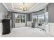 A spacious room with large windows, tray ceilings, modern lighting, and elegant wall paneling at 14466 Integrity Ct, Carmel, IN 46033