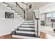 Bright, traditionally styled staircase with dark wood treads and white risers and banisters at 14466 Integrity Ct, Carmel, IN 46033