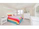 Brightly colored bedroom featuring a bed with colorful rainbow quilt and white furniture at 1457 Dominion Dr, Zionsville, IN 46077