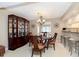 Elegant dining room with a beautiful china cabinet, dining table, and chandelier adjacent to the kitchen at 1457 Dominion Dr, Zionsville, IN 46077